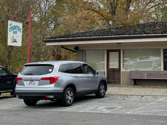 The diner from the road: front door, porch bench, and the fisherman sign above.
