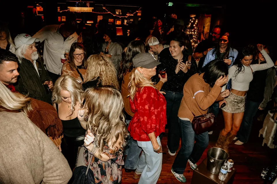 The dance floor mid-song — a crowd of people dancing under the pressed-tin ceiling.