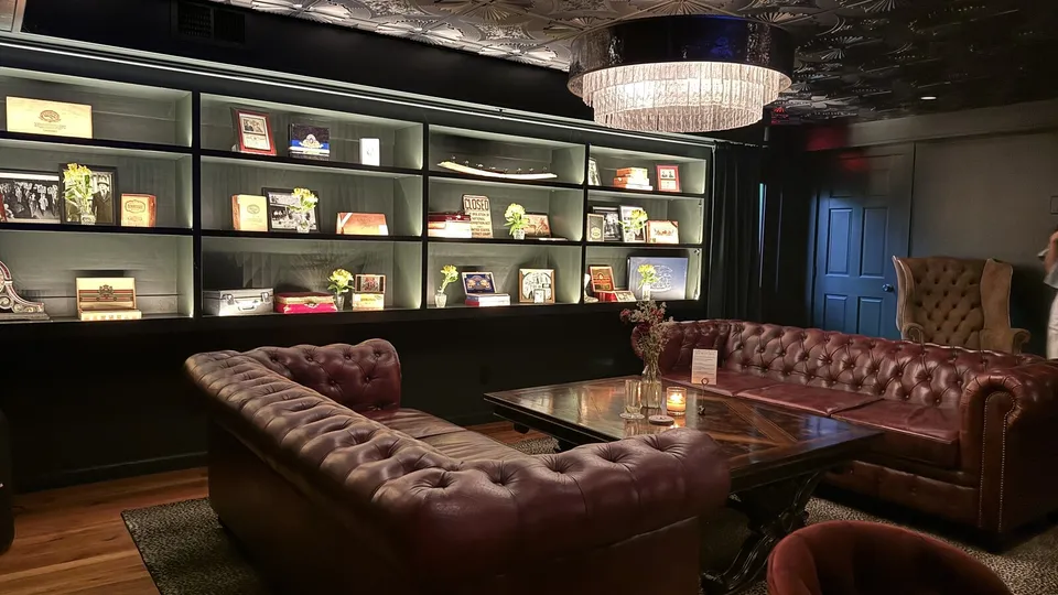 The Tornado Room lounge: oxblood Chesterfield sofas, a pressed-tin ceiling, and backlit shelves of memorabilia.